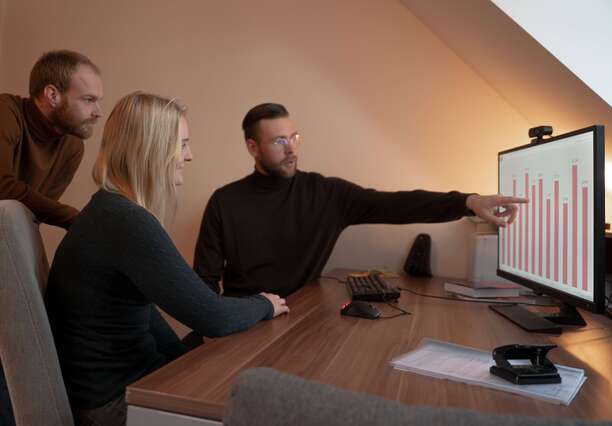 Bild von drei Personen im Meeting vor dem Computer-Bildschirm